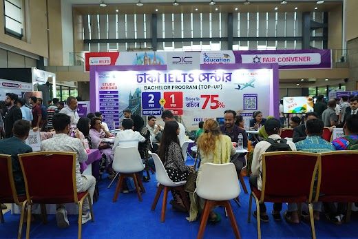 Wide exhibition hall view with counselling tables and colourful booth signage