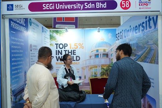 Visitors browsing the SEGi University booth on the exhibition floor