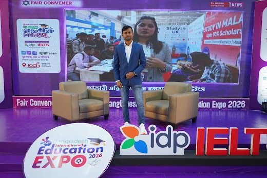 Presenter standing centre stage with Fair Convener backdrop and screens