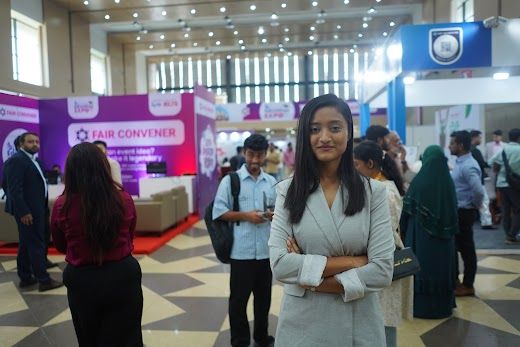 Exhibition hall aisle with booths and visitors walking the floor