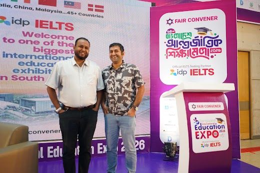 Two partners posed at the Fair Convener podium against the branded BIEE welcome backdrop