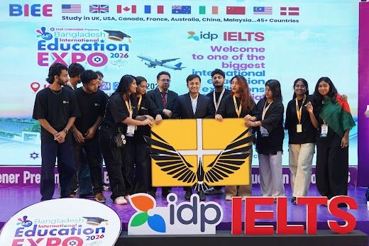 Large group of participants posing with the IDP IELTS banner on stage