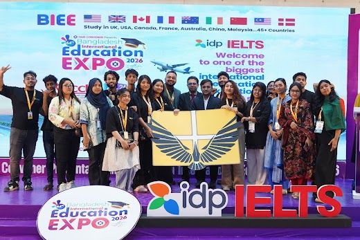 Large group holding the banner beneath the Education Expo backdrop